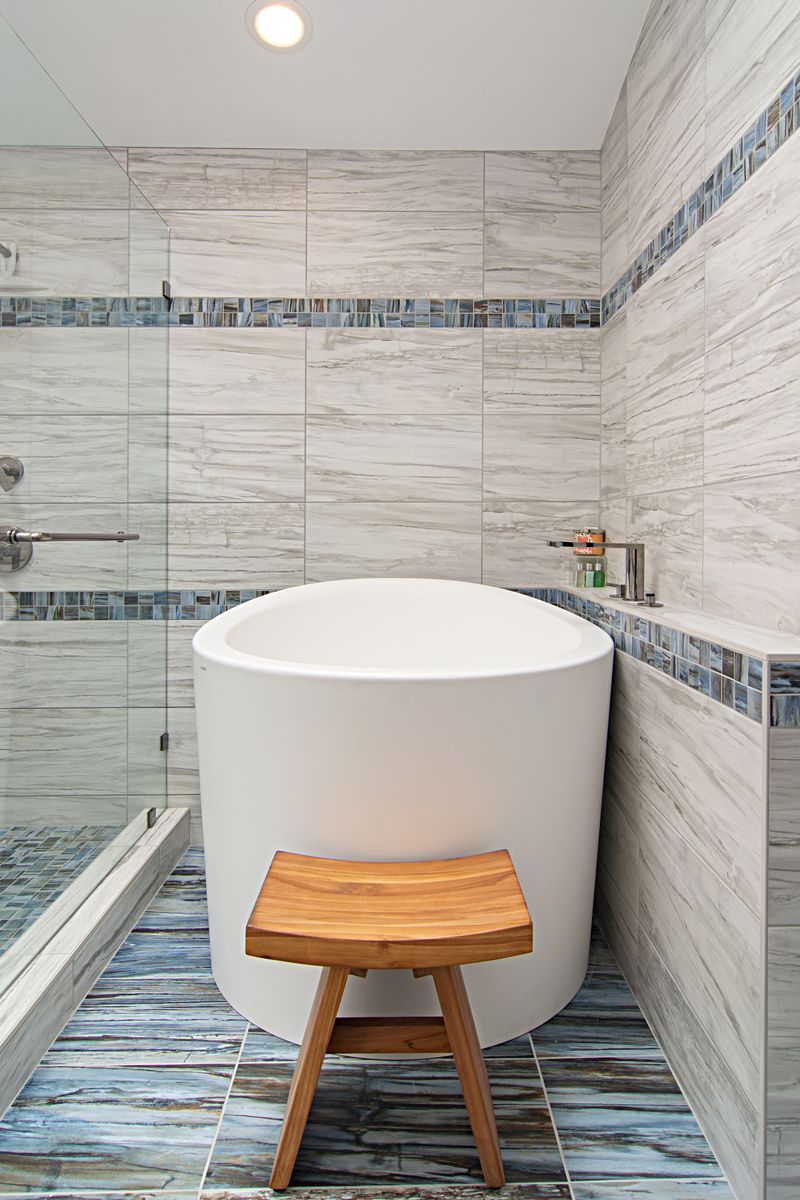 Mathis bathroom completed 23 years ago with glass tile chair rail, tiled shower with heavy glass door and glass pedestal sinks
