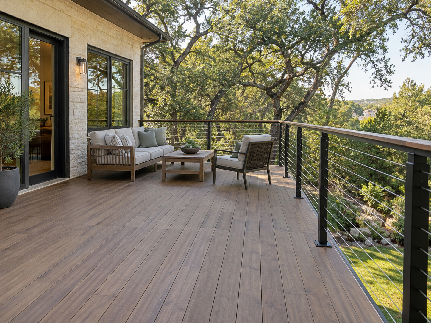 Wood deck with lounge seating and cable railing overlooking oak trees