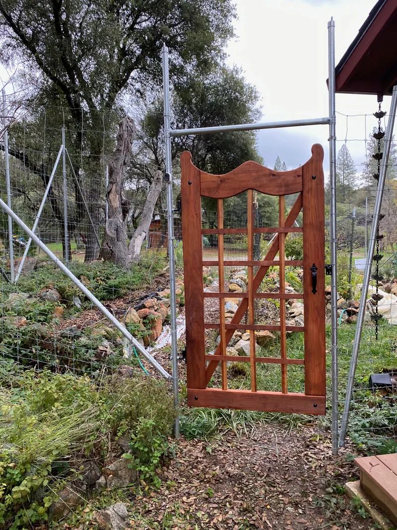 Custom wood garden gate with a curved top and lattice panel