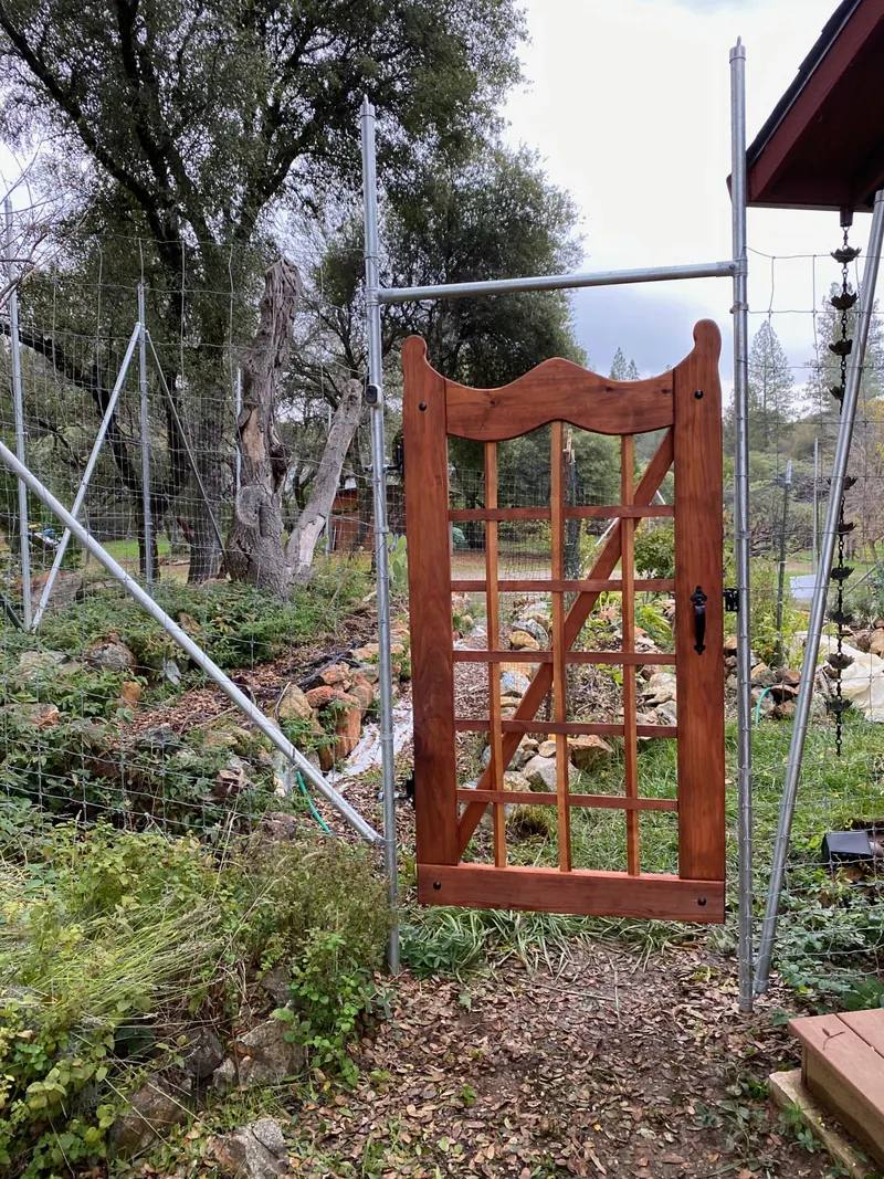 Custom wood garden gate with a curved top and lattice panel