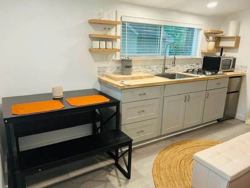 Compact kitchenette with butcher block counter in a guest studio