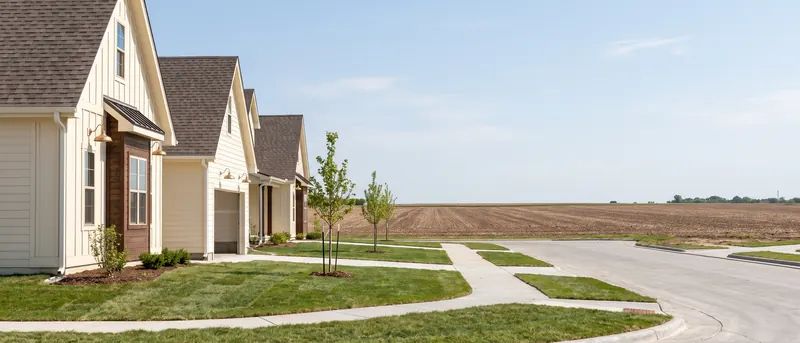 Flat new subdivision street in Wolfforth with open farmland beyond the last houses