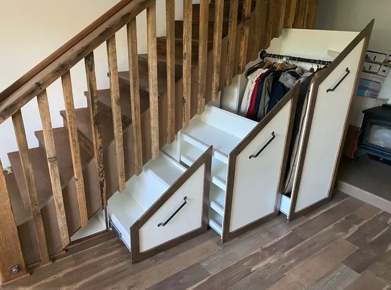 Custom pull-out storage drawers built under a staircase