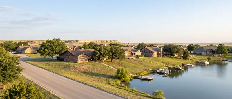 Winding road along the lake shore in Ransom Canyon with homes stepped up the canyon wall