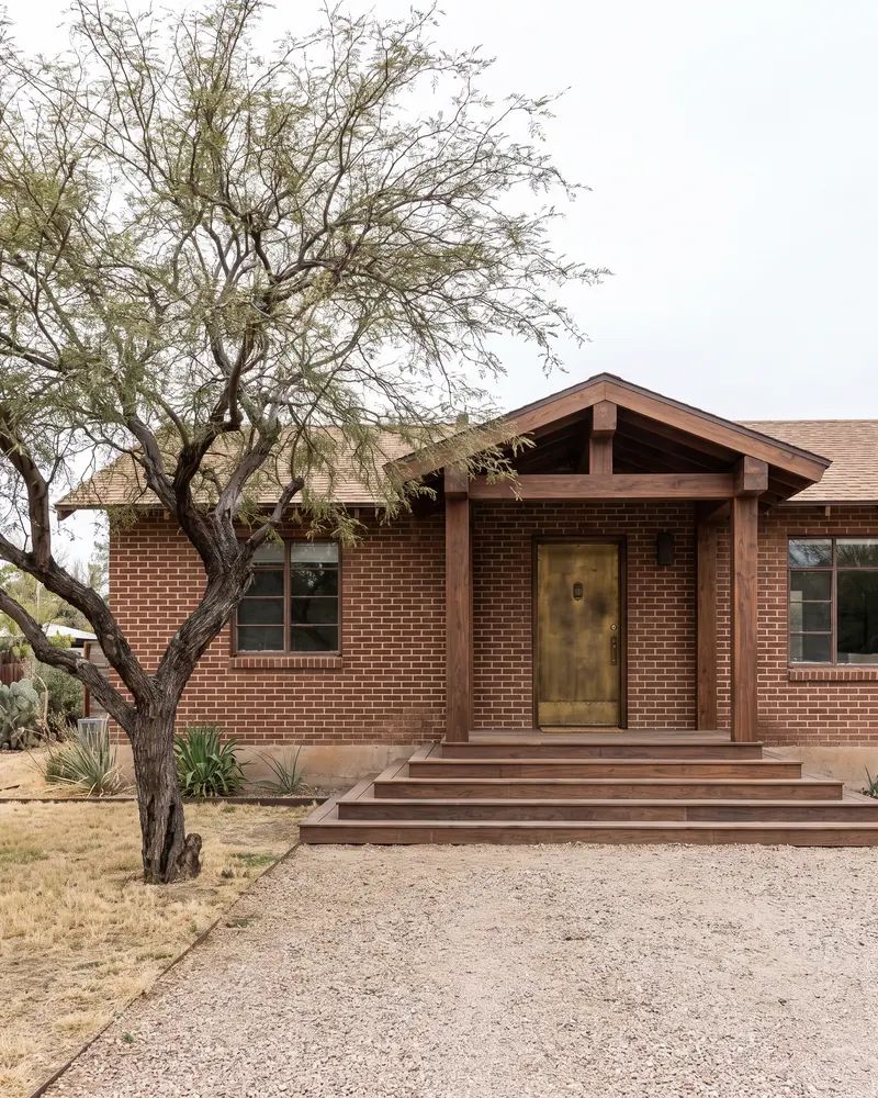 Older brick home in a small West Texas town with a new timber framed entry and wide wood steps