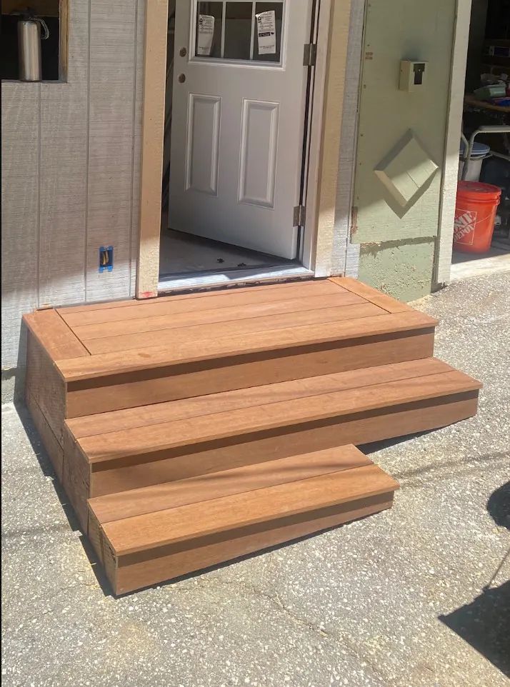 Wide wood entry steps built to fit a landing on two slopes