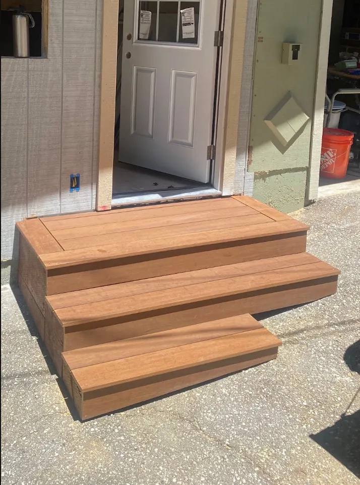 Wide wood entry steps built to fit a landing on two slopes