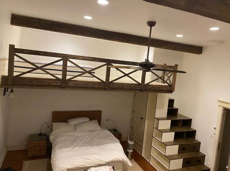 Bedroom with a custom wood loft and built-in storage stairs