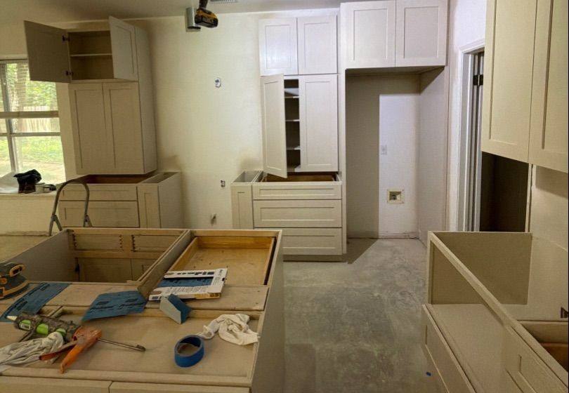 Before and after photo of kitchen cabinets refinished by Hill Country Painting in Round Rock, TX
