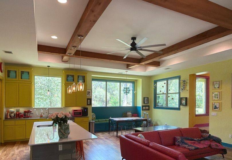 Before and after photo of a living room and kitchen repainted by Hill Country Painting in Austin, TX