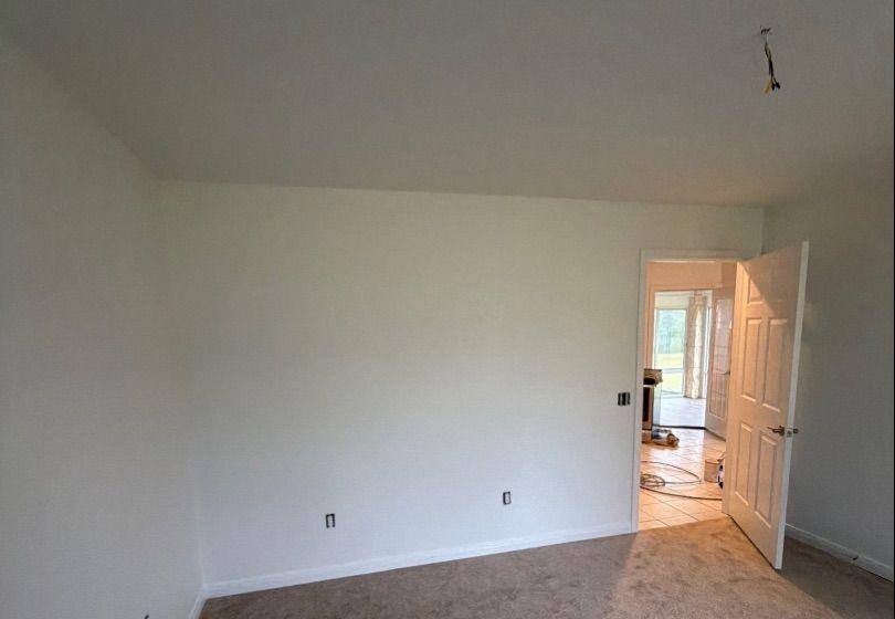 Before and after photo of a bedroom repainted by Hill Country Painting in Dripping Springs, TX