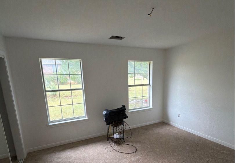 Before and after photo of a bright bedroom repainted by Hill Country Painting in Dripping Springs, TX