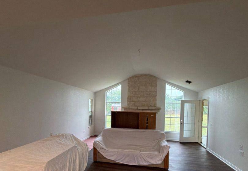 Before and after photo of a living room with a fireplace repainted by Hill Country Painting in Dripping Springs, TX
