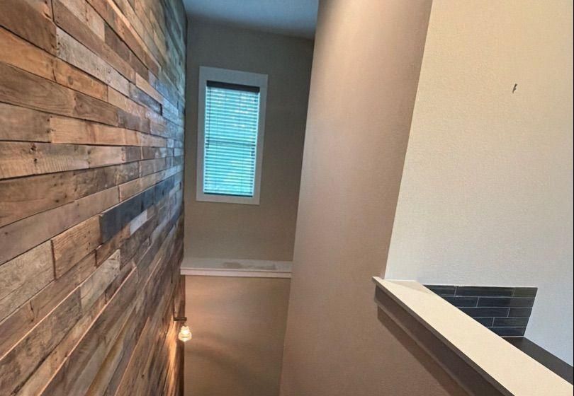 Before and after photo of a stairwell repainted by Hill Country Painting in Spicewood, TX