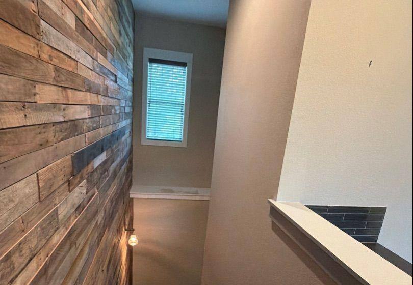 Before and after photo of a stairwell repainted by Hill Country Painting in Spicewood, TX