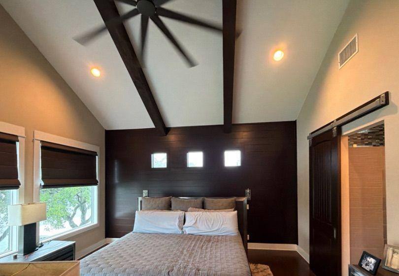 Before and after photo of a bedroom accent wall and barn door repainted by Hill Country Painting in Spicewood, TX