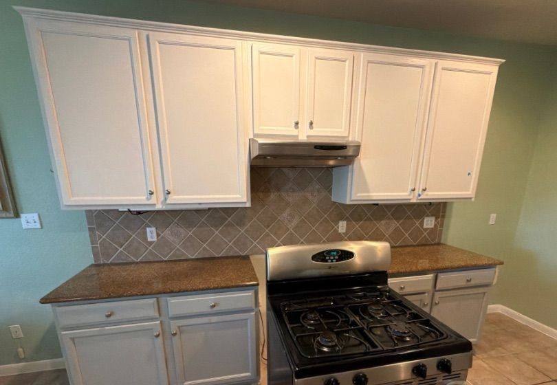 Before and after photo of kitchen upper cabinets painted by Hill Country Painting in Round Rock, TX
