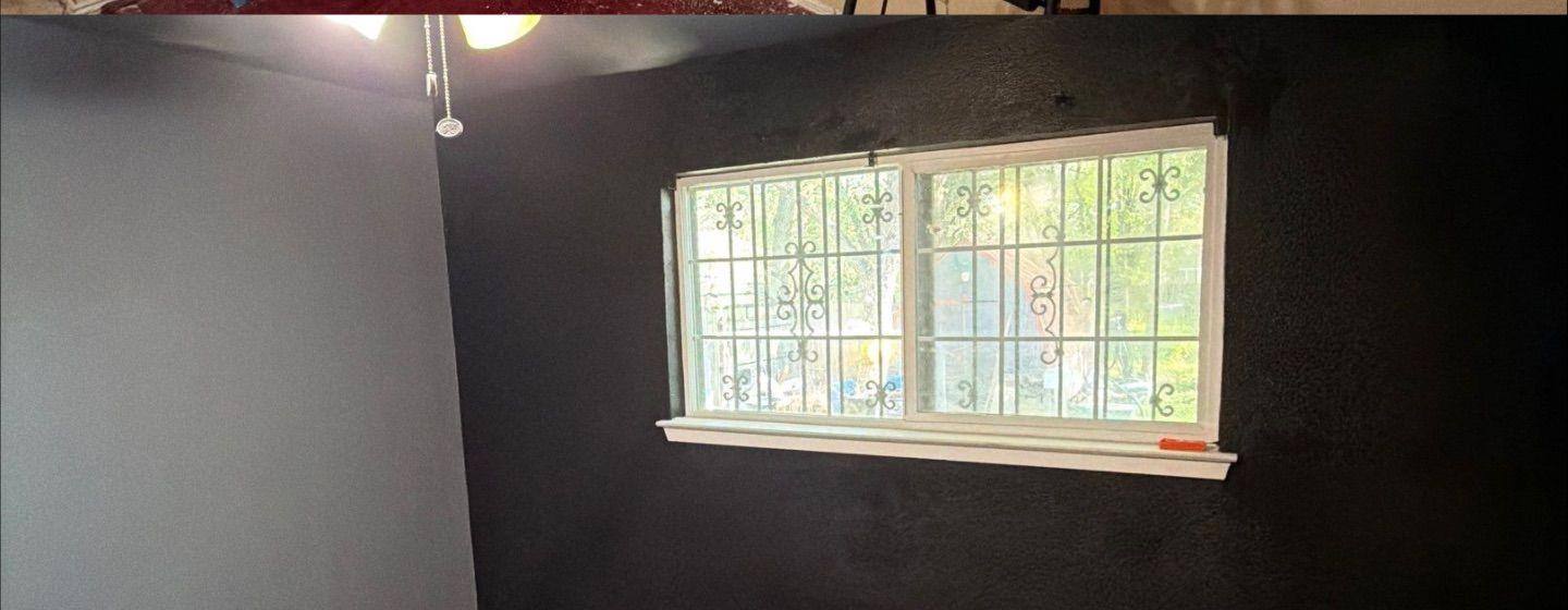 Before and after photo of a bedroom wall repair and repaint by Hill Country Painting in Austin, TX