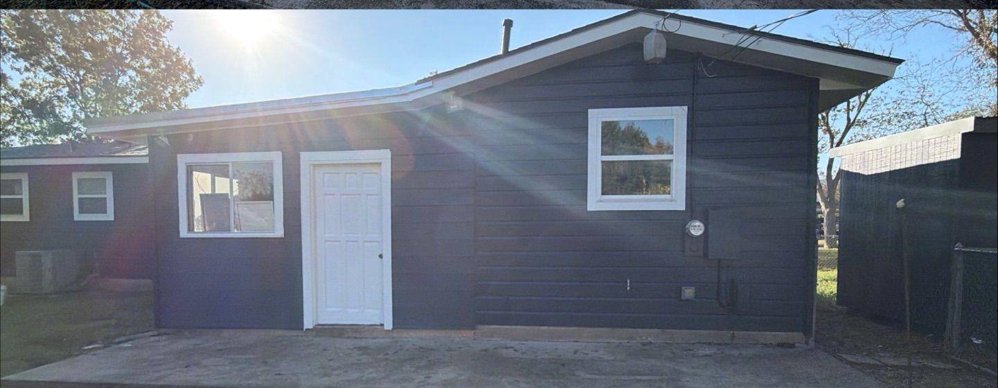 Before and after photo of a house side exterior painted by Hill Country Painting in Taylor, TX
