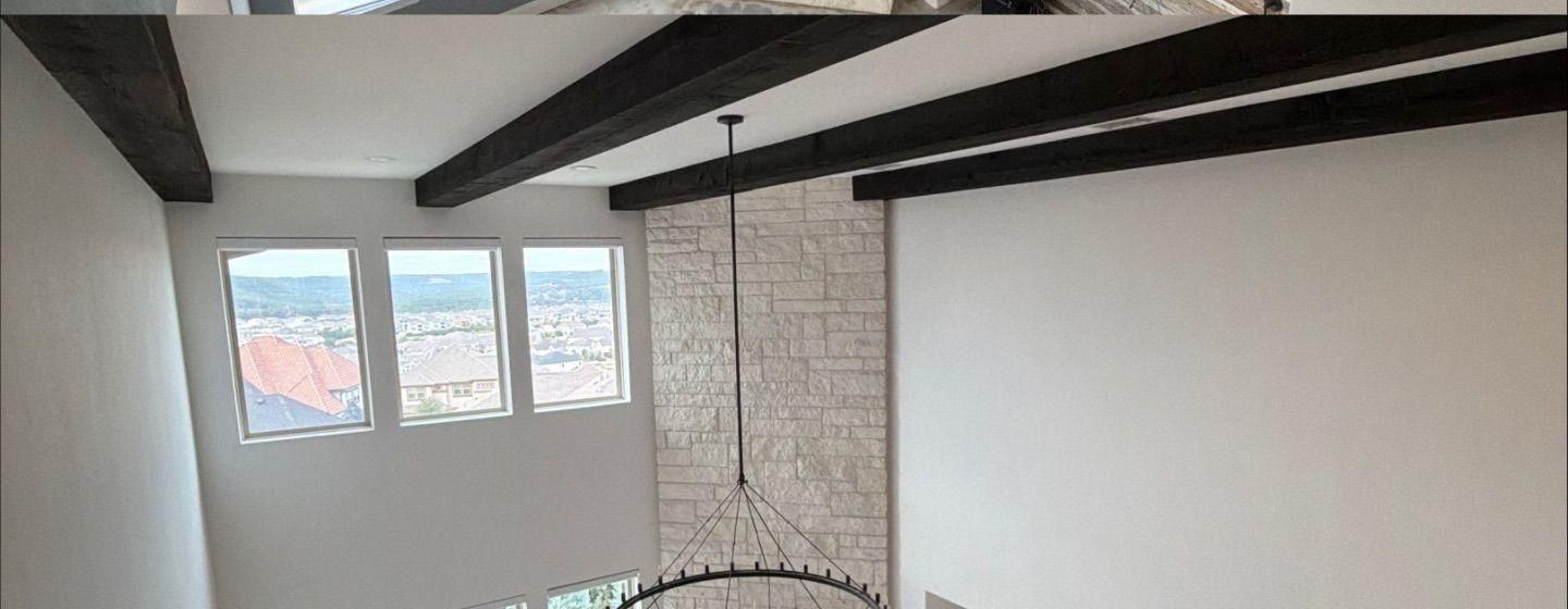 Before and after photo of a two-story great room painted by Hill Country Painting in Leander, TX