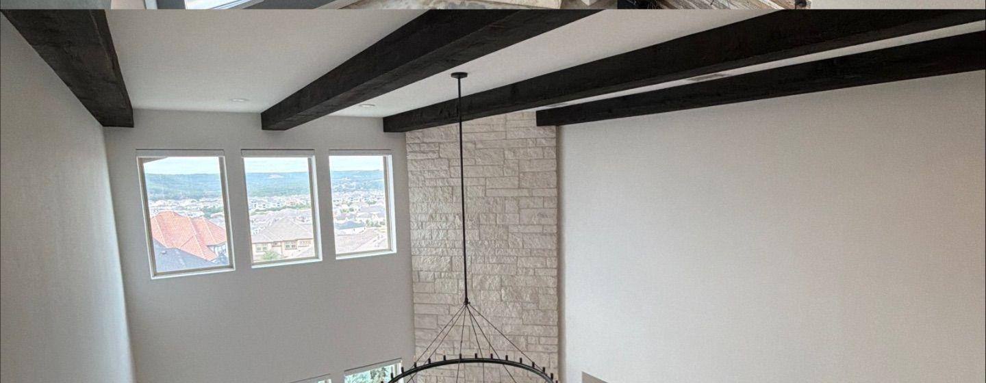 Before and after photo of a two-story great room painted by Hill Country Painting in Leander, TX