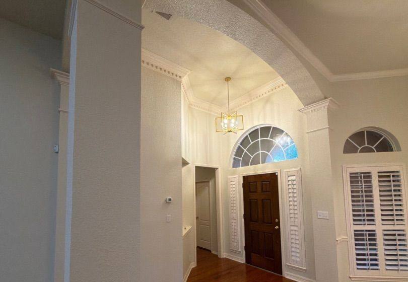 Before and after photo of a two-story entry way painted by Hill Country Painting in Cedar Park, TX