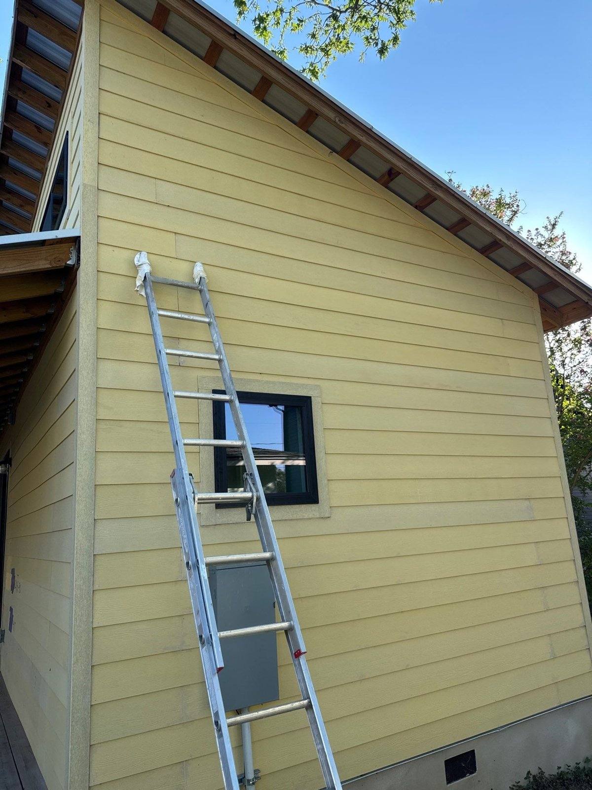 Gable end of a home in Austin, TX with Hardie siding prepped for exterior painting by Hill Country Painting
