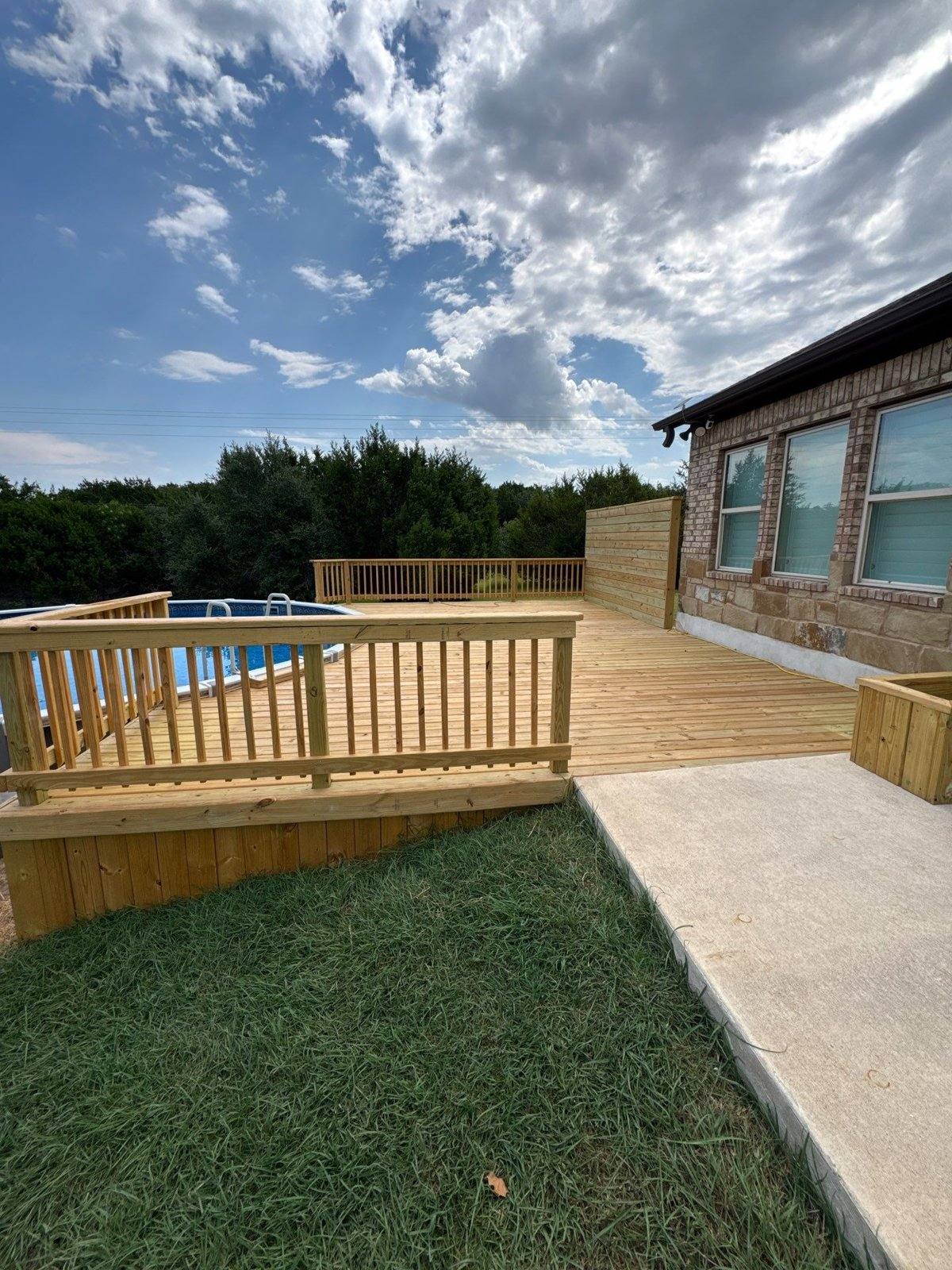 New wood deck with above-ground pool at a home in Liberty Hill, TX ahead of staining by Hill Country Painting