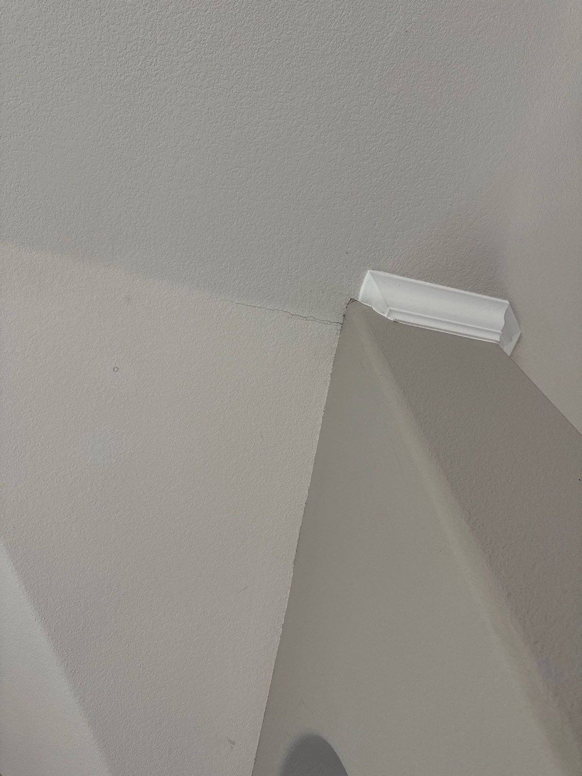 Settle crack at a ceiling corner with a crown molding sample, ahead of repair and repaint in Cedar Park, TX by Hill Country Painting