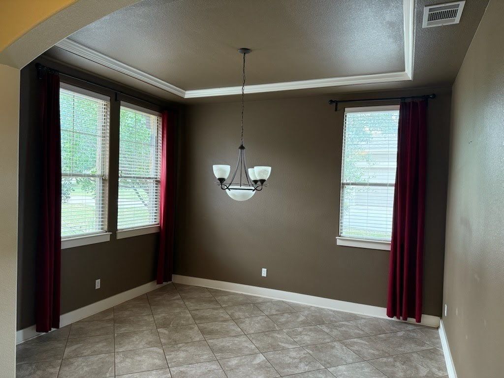 Front room with tray ceiling and crown molding ahead of drywall repair and repaint in Driftwood, TX by Hill Country Painting