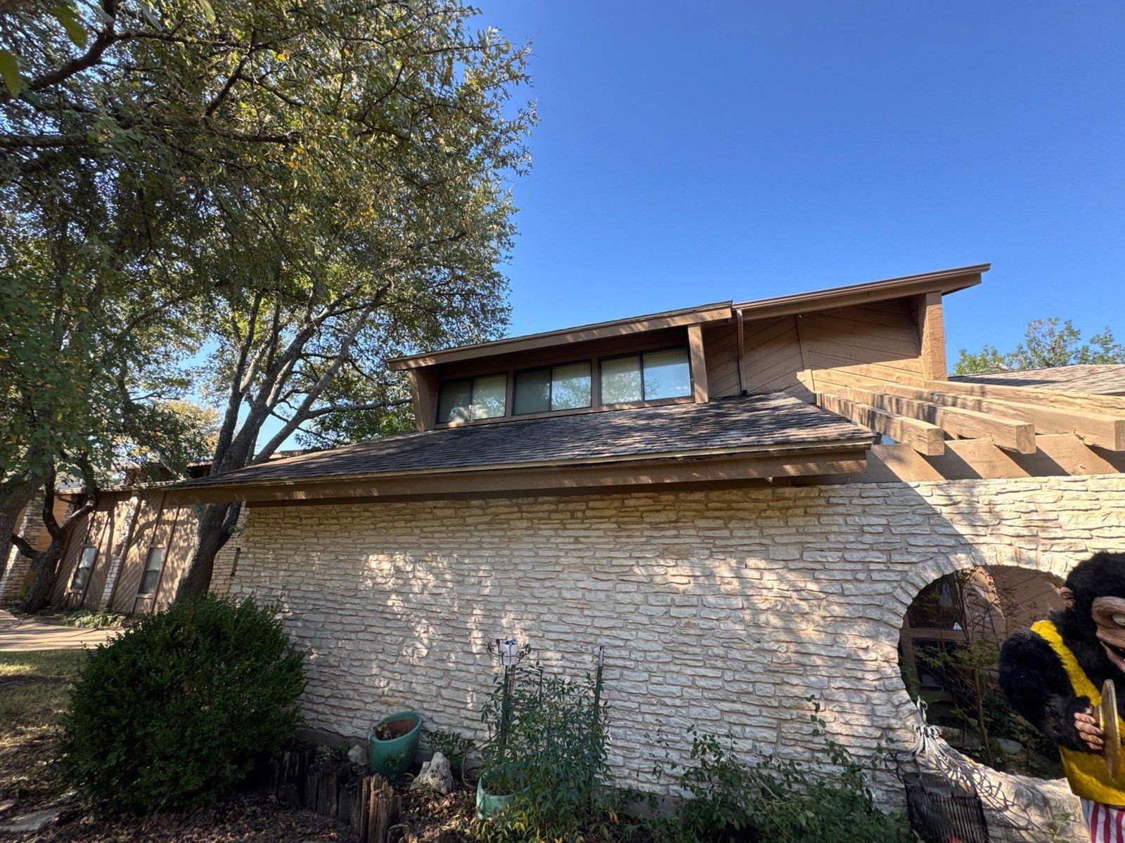Stone and wood gable exterior ahead of a repaint in Austin, TX by Hill Country Painting