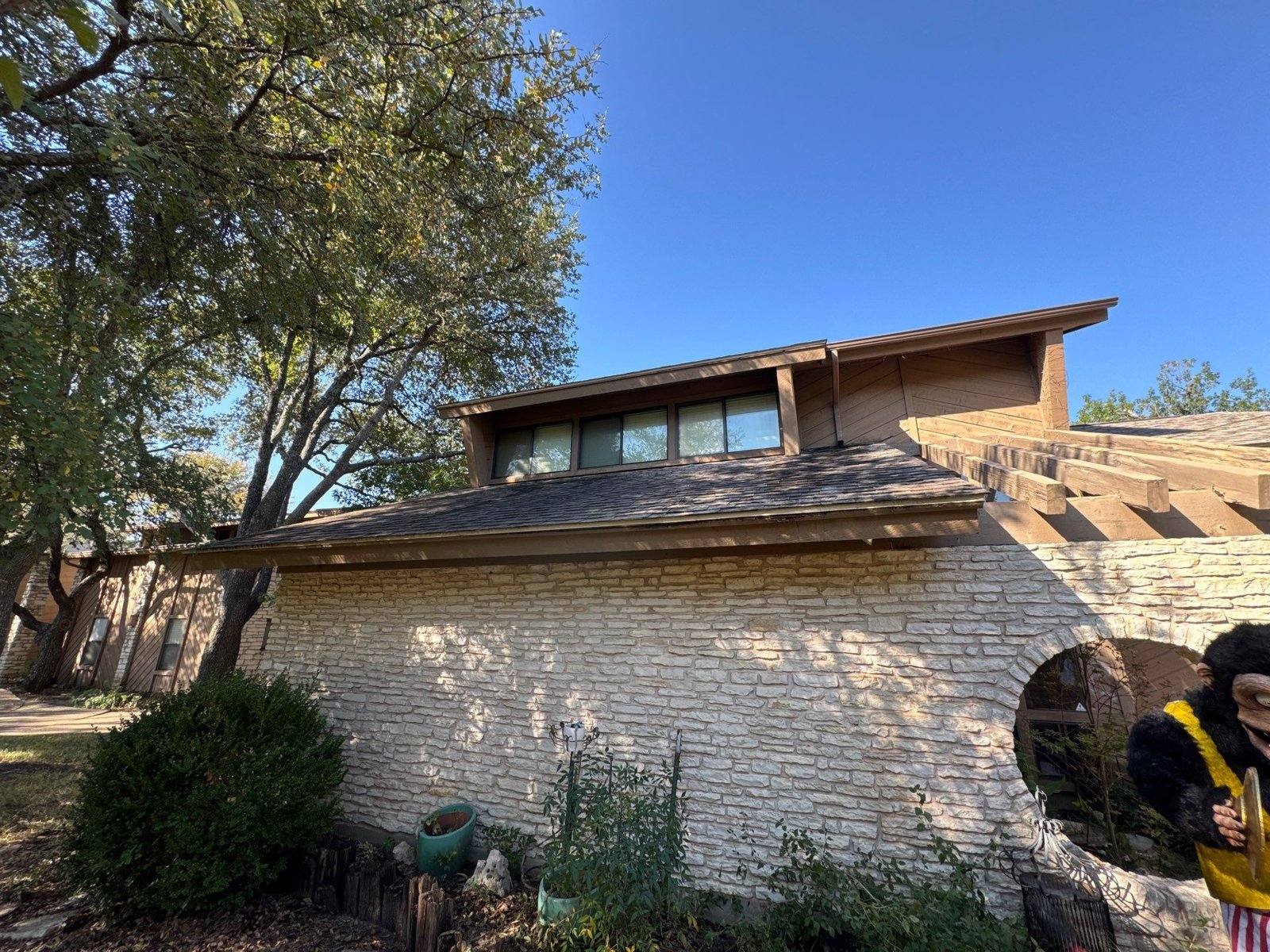 Stone and wood gable exterior ahead of a repaint in Austin, TX by Hill Country Painting