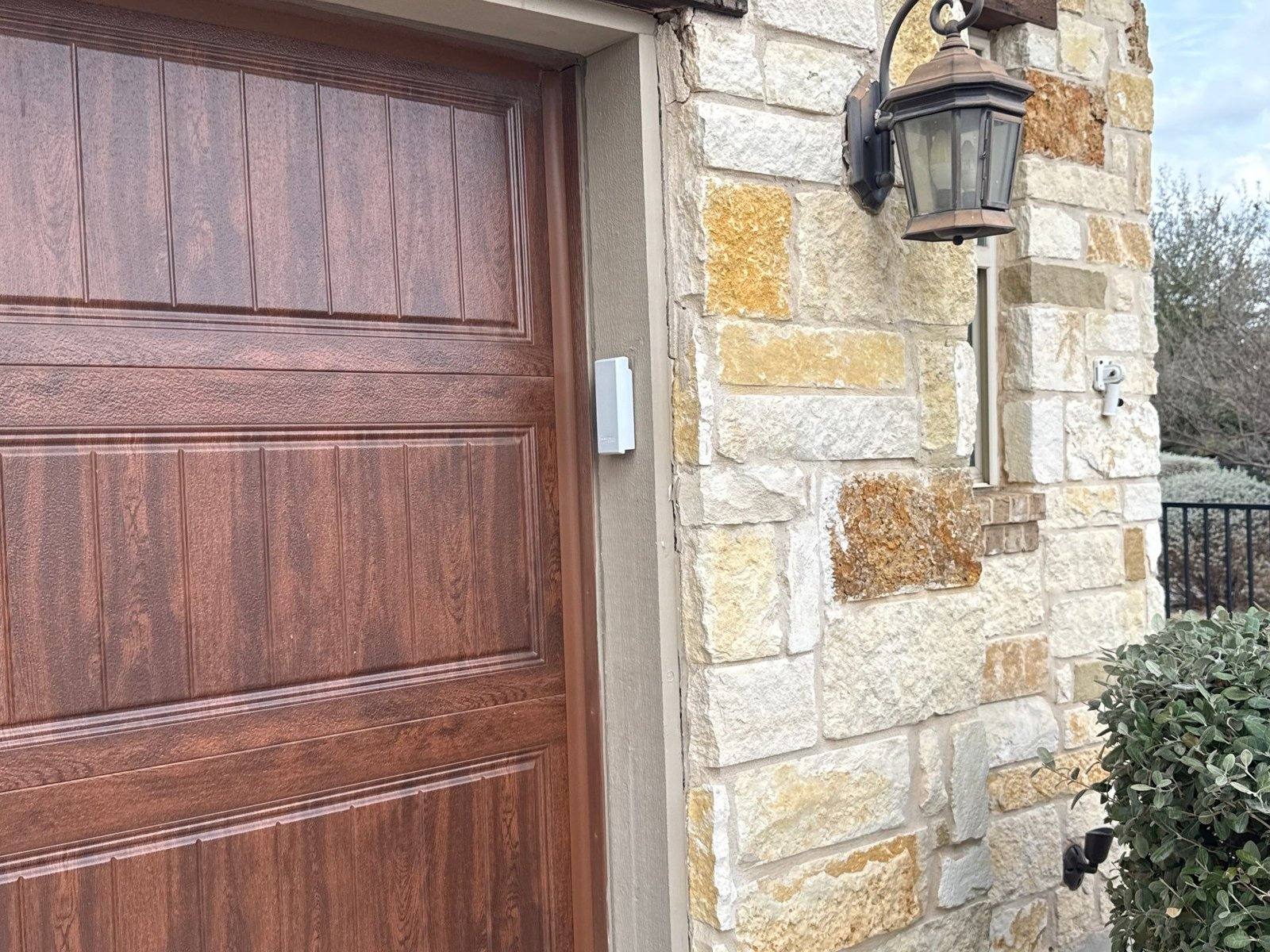 Garage door and stone entry before painting in Georgetown, TX by Hill Country Painting