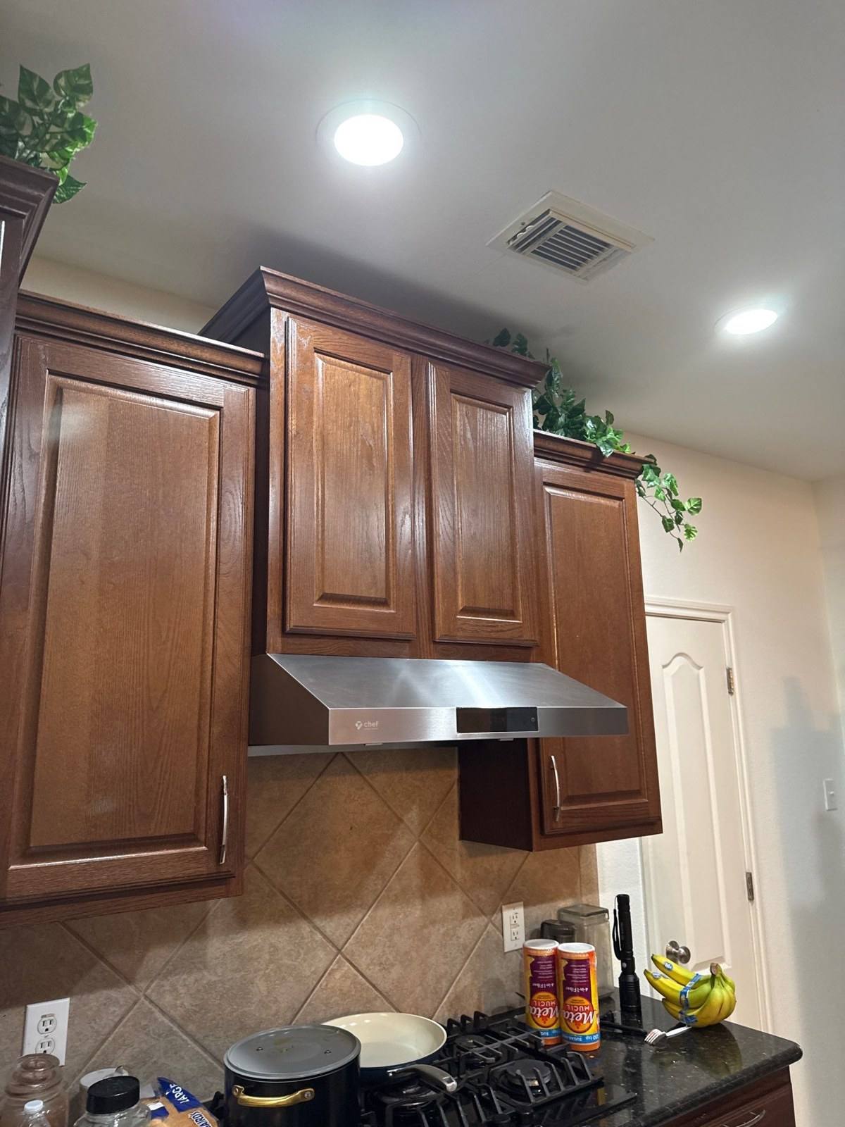 Kitchen cabinets and range hood before painting in Cedar Park, TX by Hill Country Painting