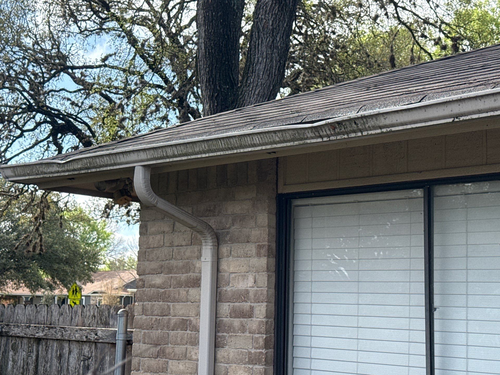Back corner and gutters ahead of exterior painting in Austin, TX by Hill Country Painting