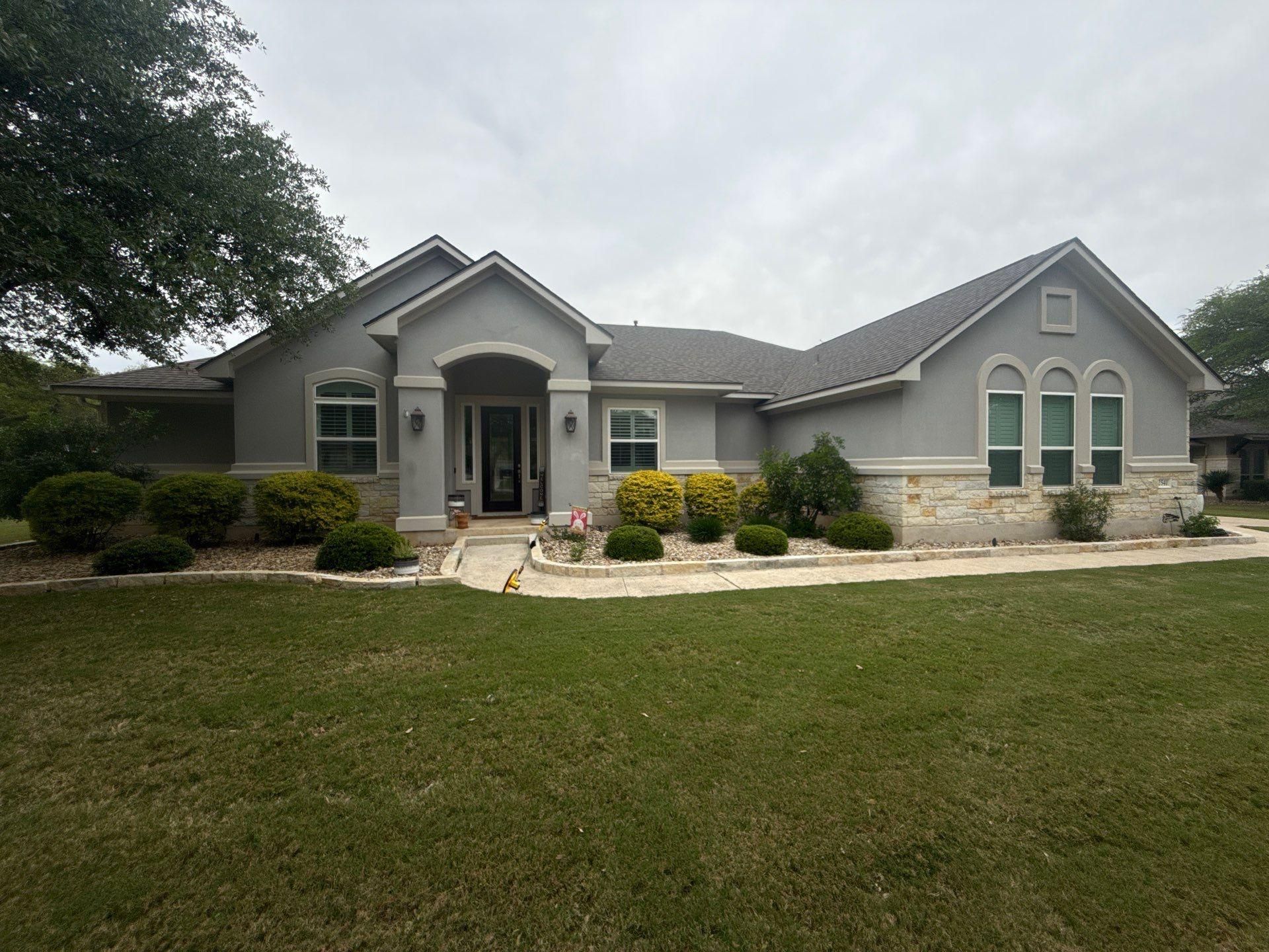 Front elevation of a stucco and stone home ahead of exterior painting in Leander, TX by Hill Country Painting