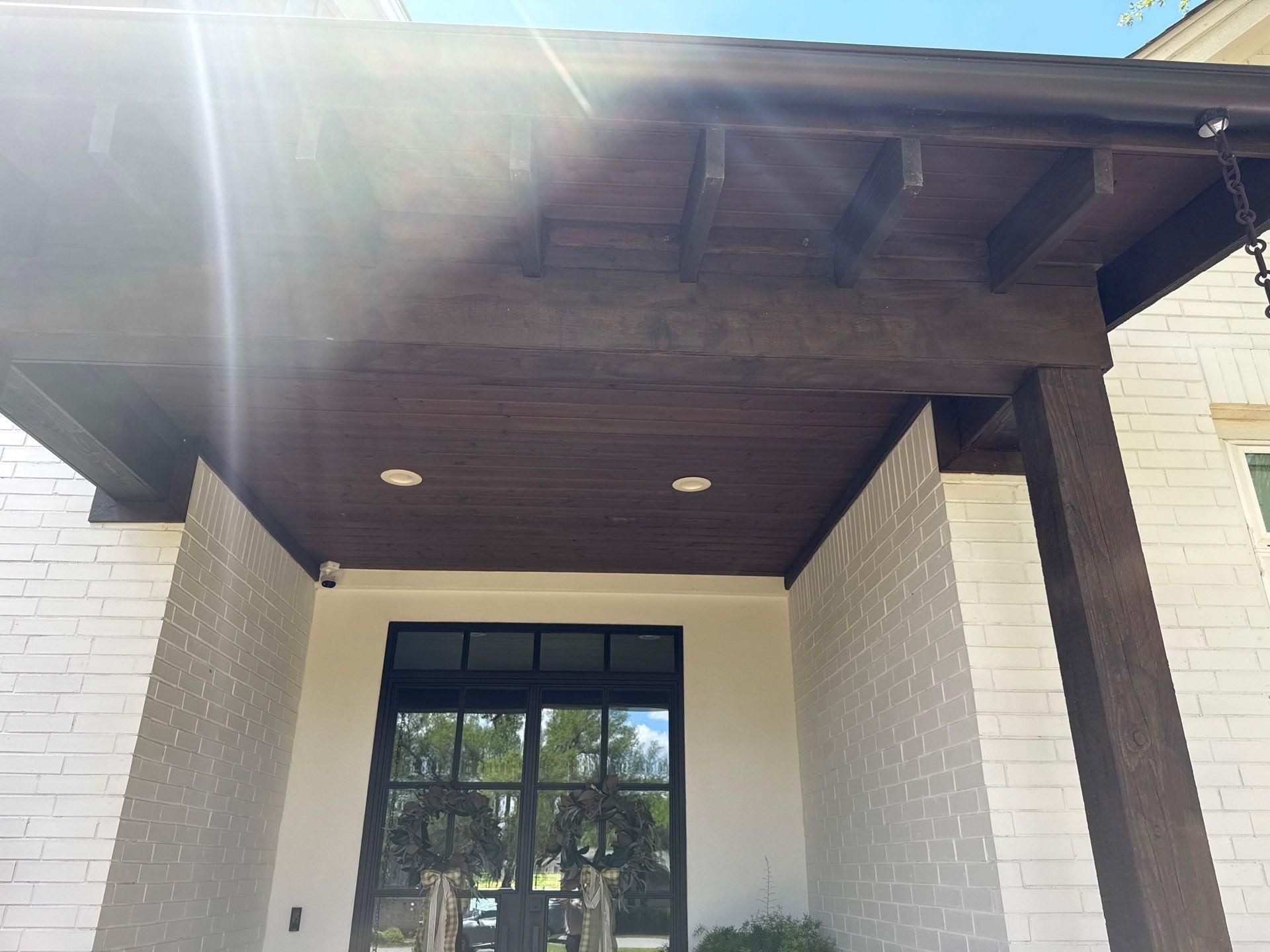 Front porch with wood beam ceiling and columns ahead of exterior painting in Lakeway, TX by Hill Country Painting