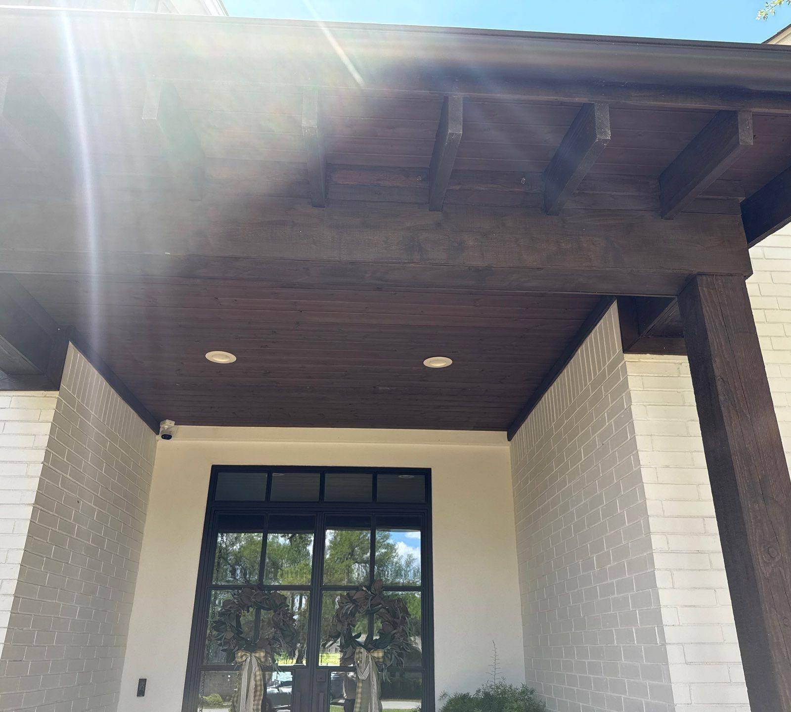 Front porch with wood beam ceiling and columns ahead of exterior painting in Lakeway, TX by Hill Country Painting