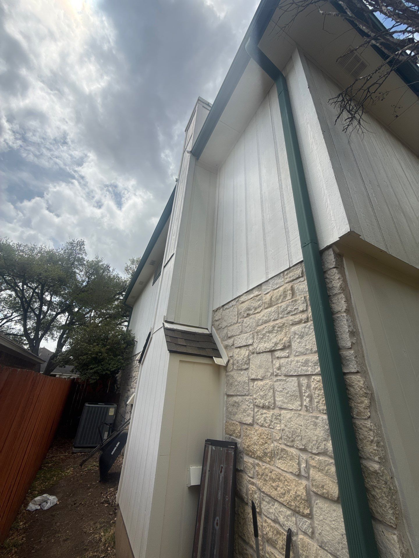 Side elevation with stone siding ahead of exterior painting in Austin, TX by Hill Country Painting