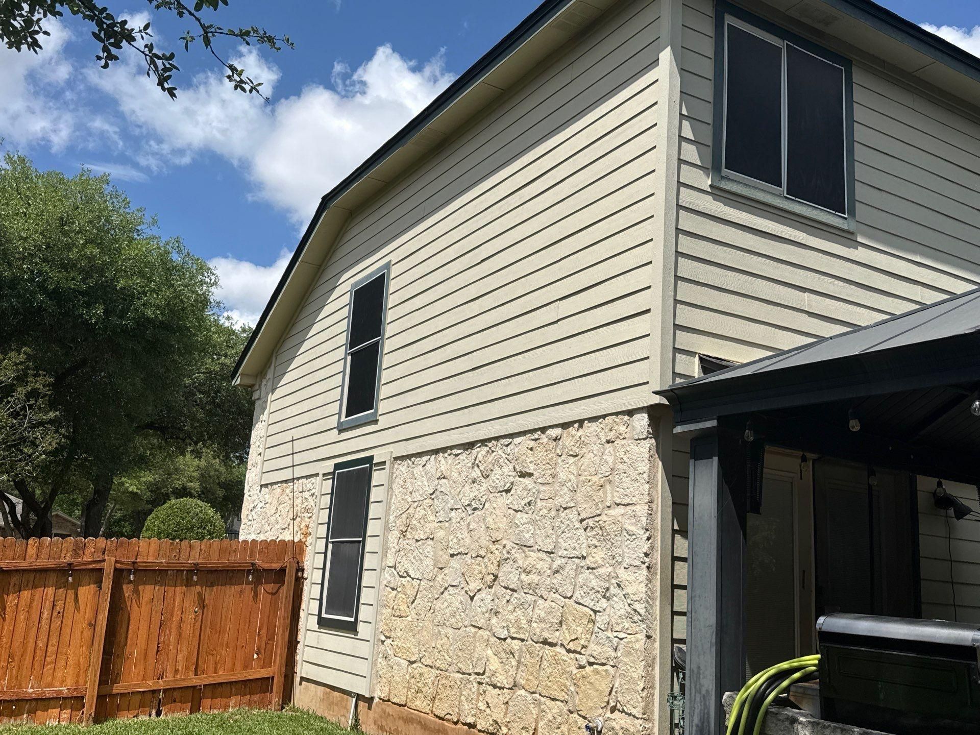 Side elevation with stone and siding and covered porch ahead of exterior painting in Cedar Park, TX by Hill Country Painting