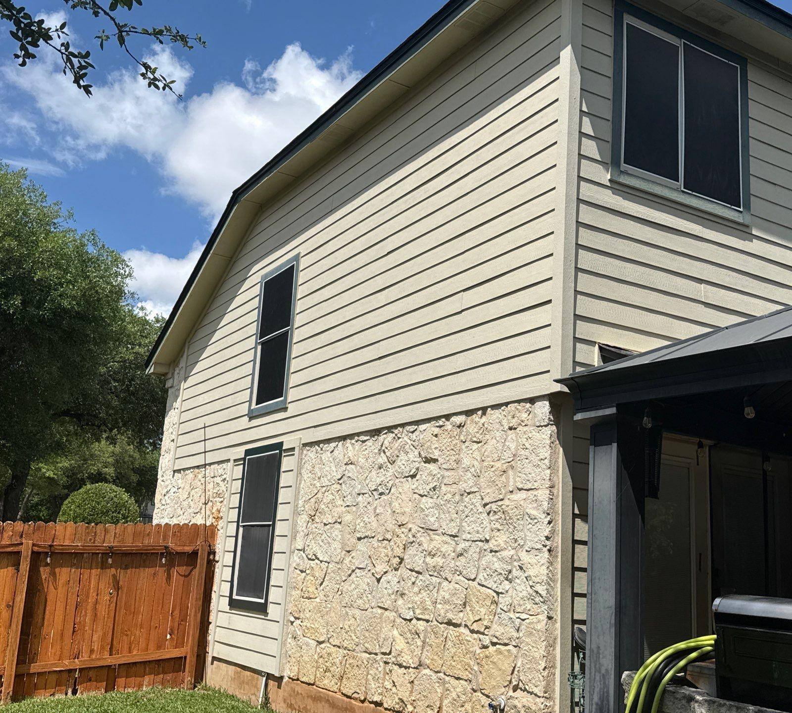 Side elevation with stone and siding and covered porch ahead of exterior painting in Cedar Park, TX by Hill Country Painting