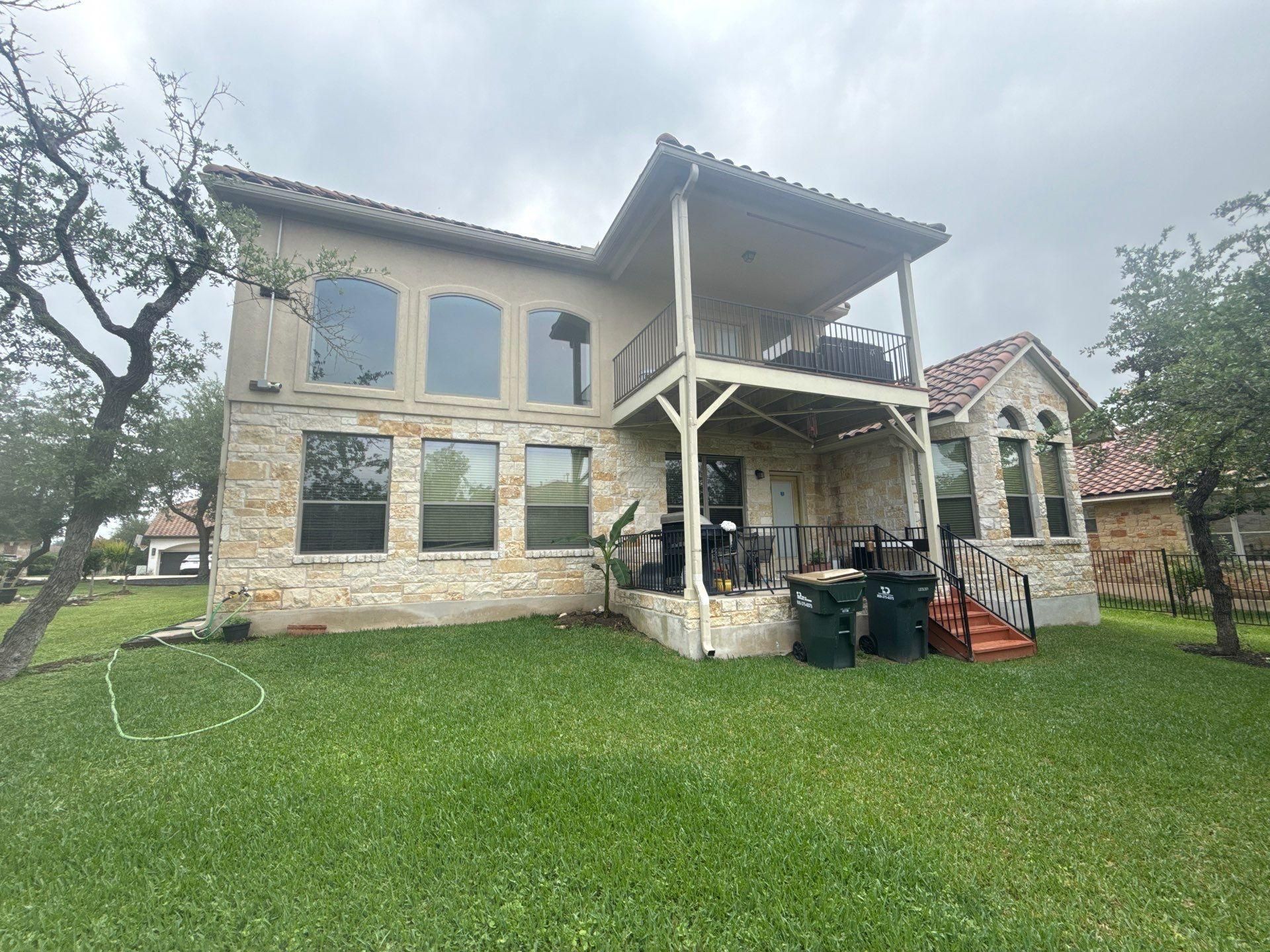 Back elevation of a two-story home in Bee Cave, TX ahead of exterior painting by Hill Country Painting