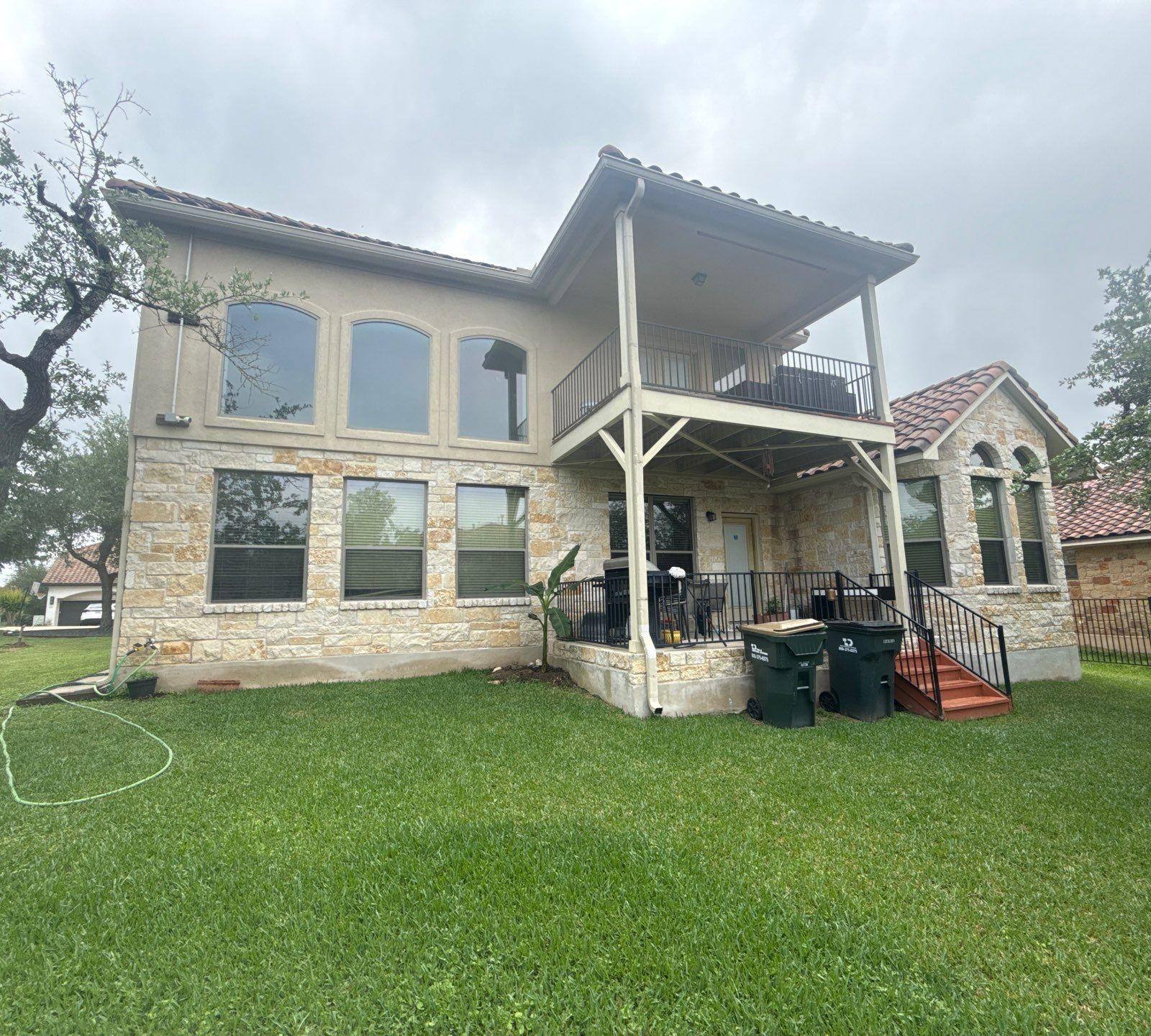 Back elevation of a two-story home in Bee Cave, TX ahead of exterior painting by Hill Country Painting
