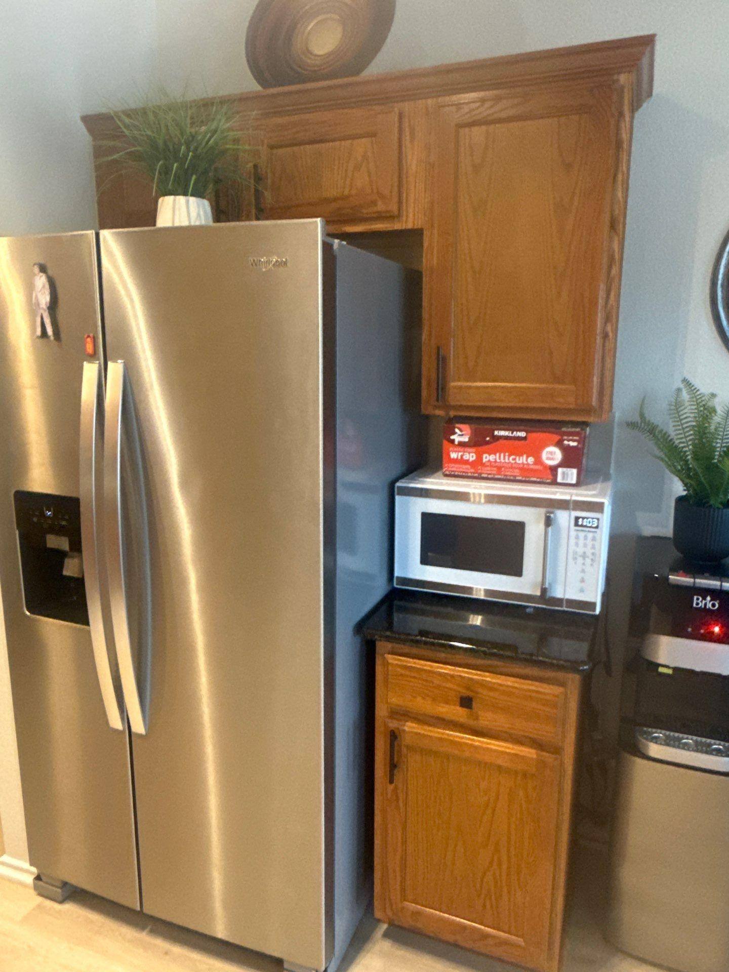 Kitchen cabinet surrounding the refrigerator of a home in Austin, TX ahead of cabinet refinishing by Hill Country Painting