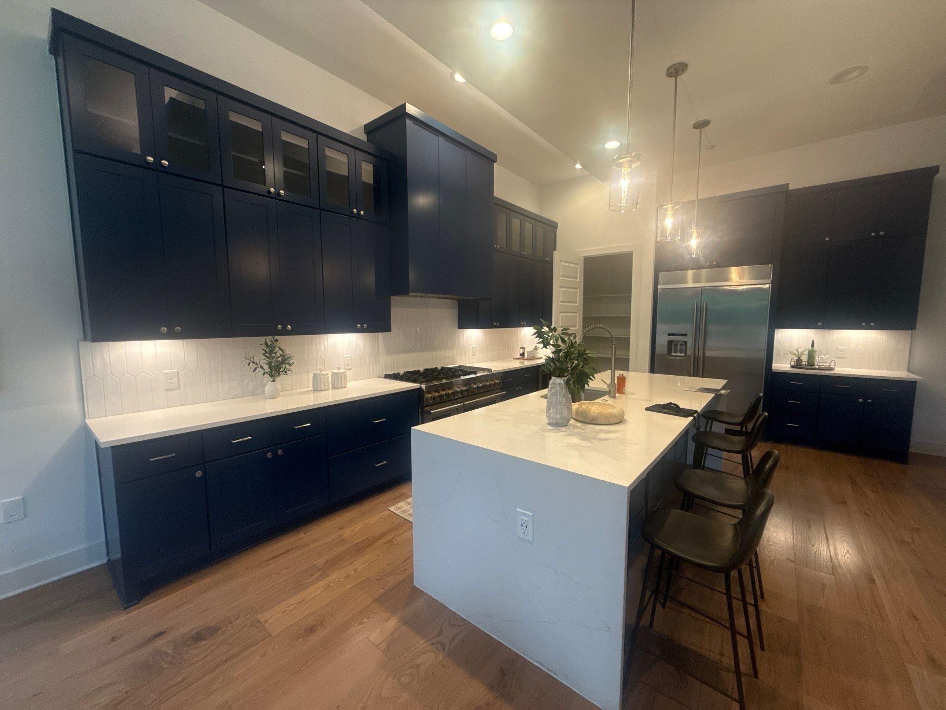 Kitchen with navy cabinetry of a home in Austin, TX ahead of interior painting and cabinet refinishing by Hill Country Painting