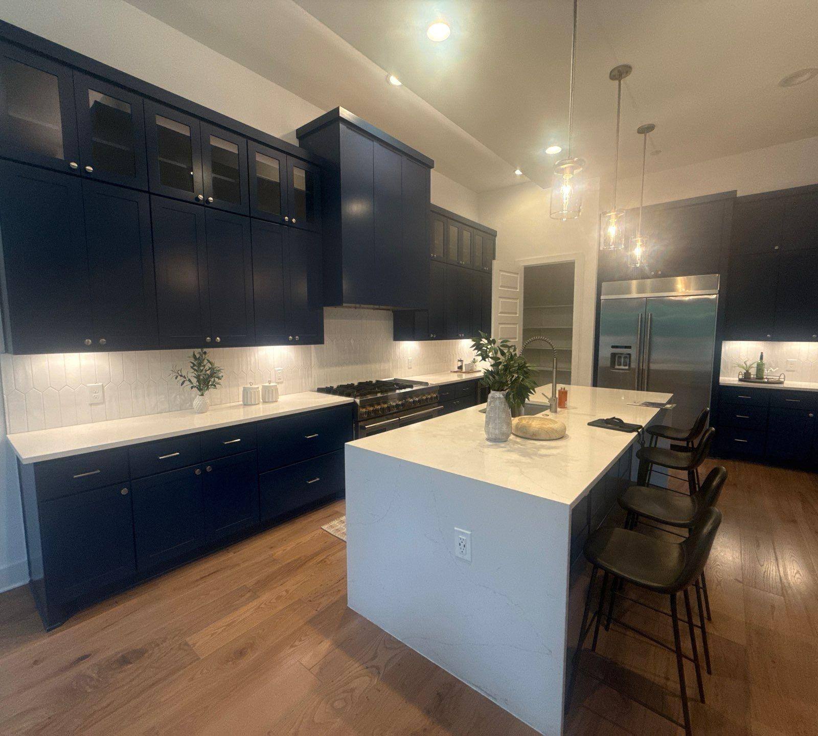 Kitchen with navy cabinetry of a home in Austin, TX ahead of interior painting and cabinet refinishing by Hill Country Painting