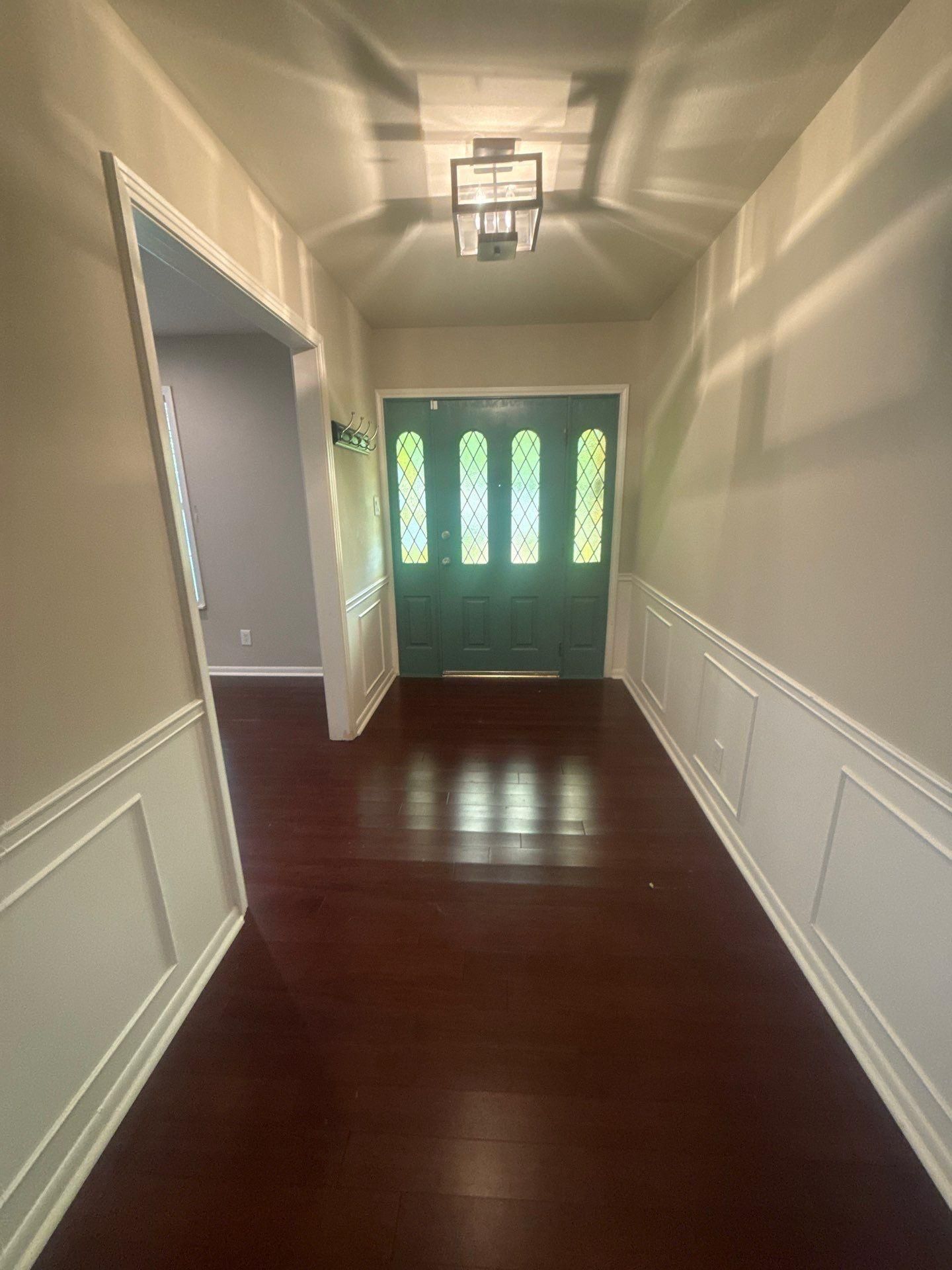 Entryway with stained glass front door in a home in Austin, TX ahead of interior painting by Hill Country Painting