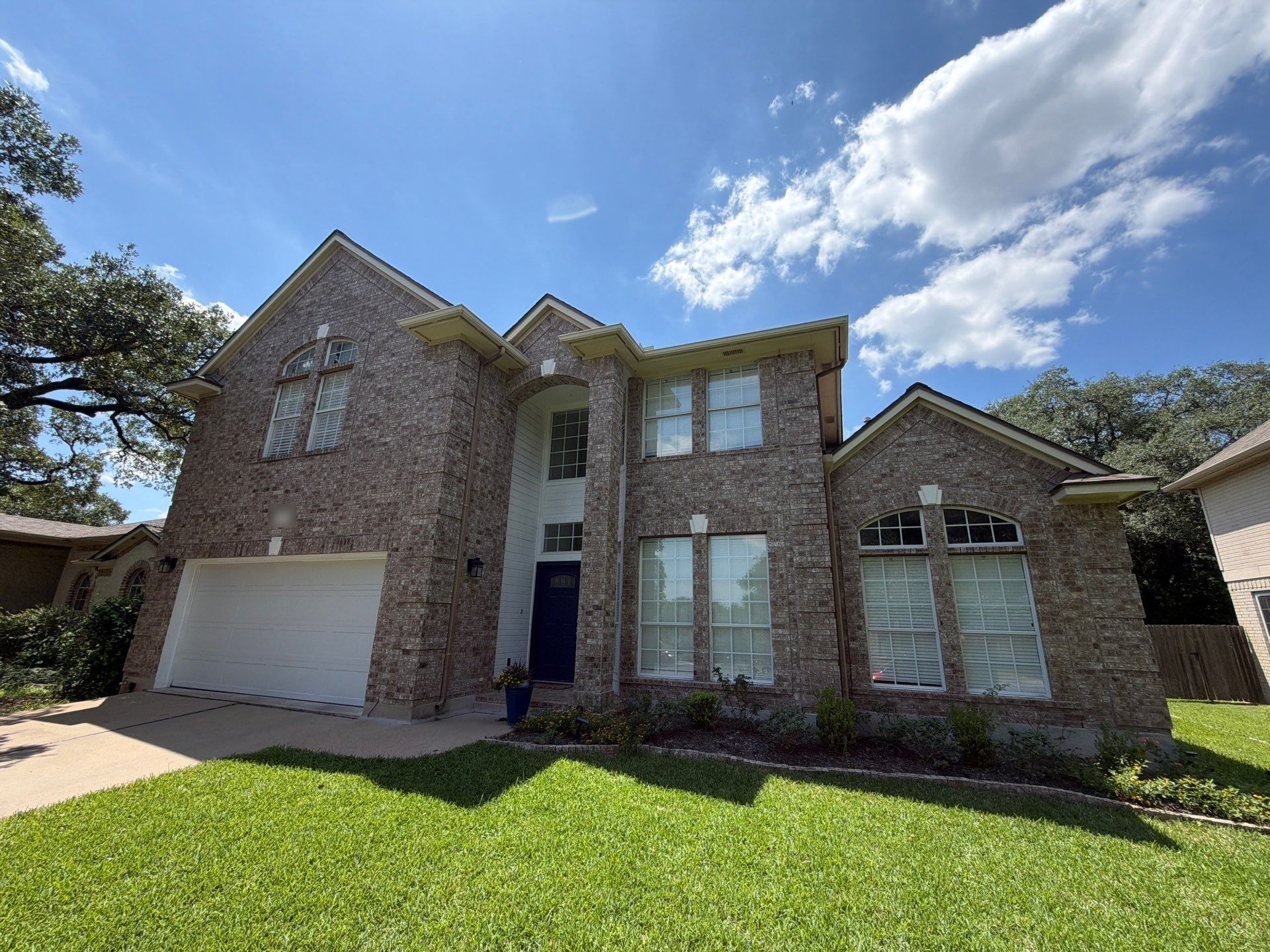 Two-story brick home on Bending Oak Rd in Austin, TX ahead of exterior painting by Hill Country Painting