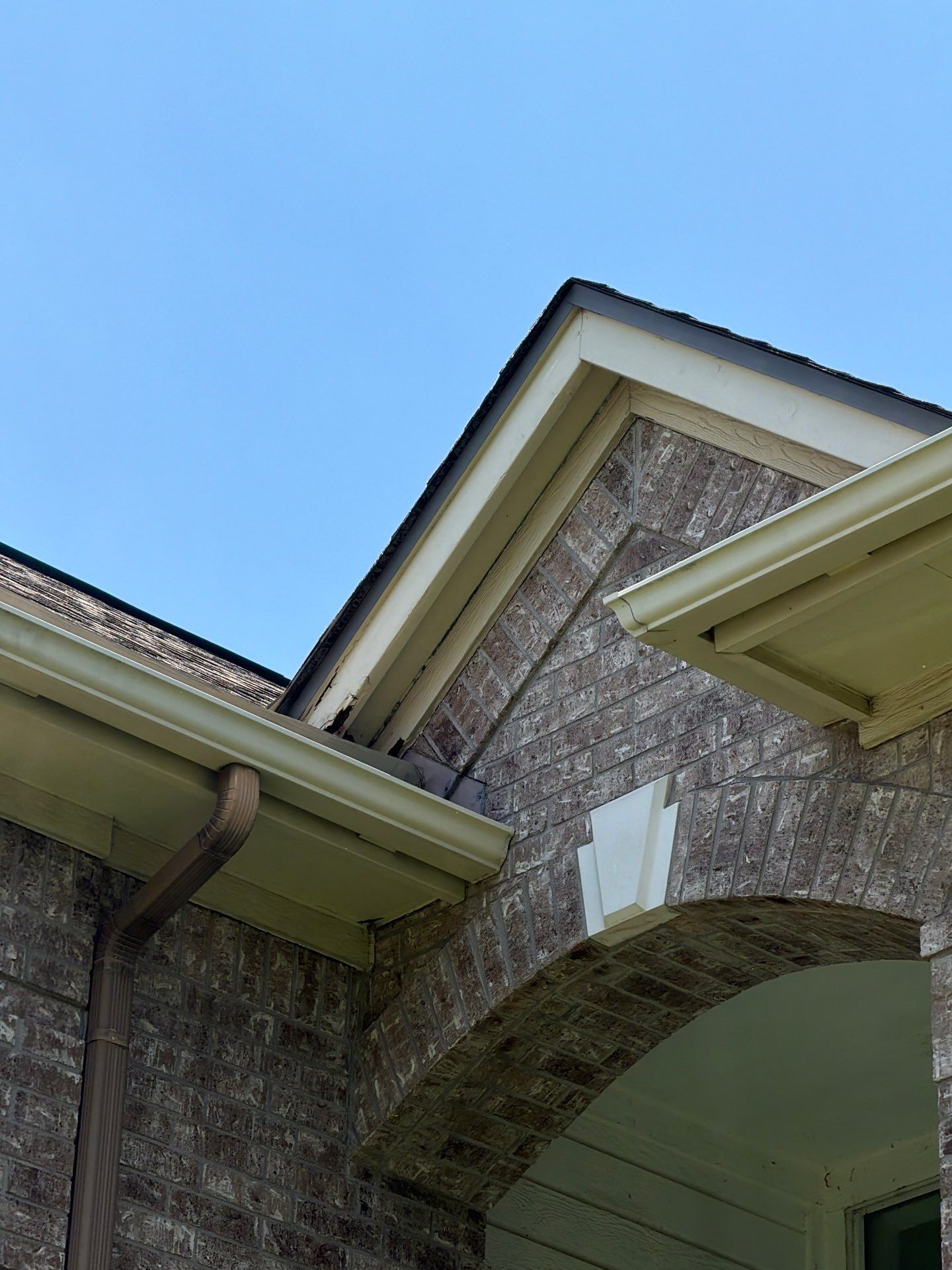 Front porch archway and gutter detail on a home in Austin, TX ahead of exterior painting by Hill Country Painting