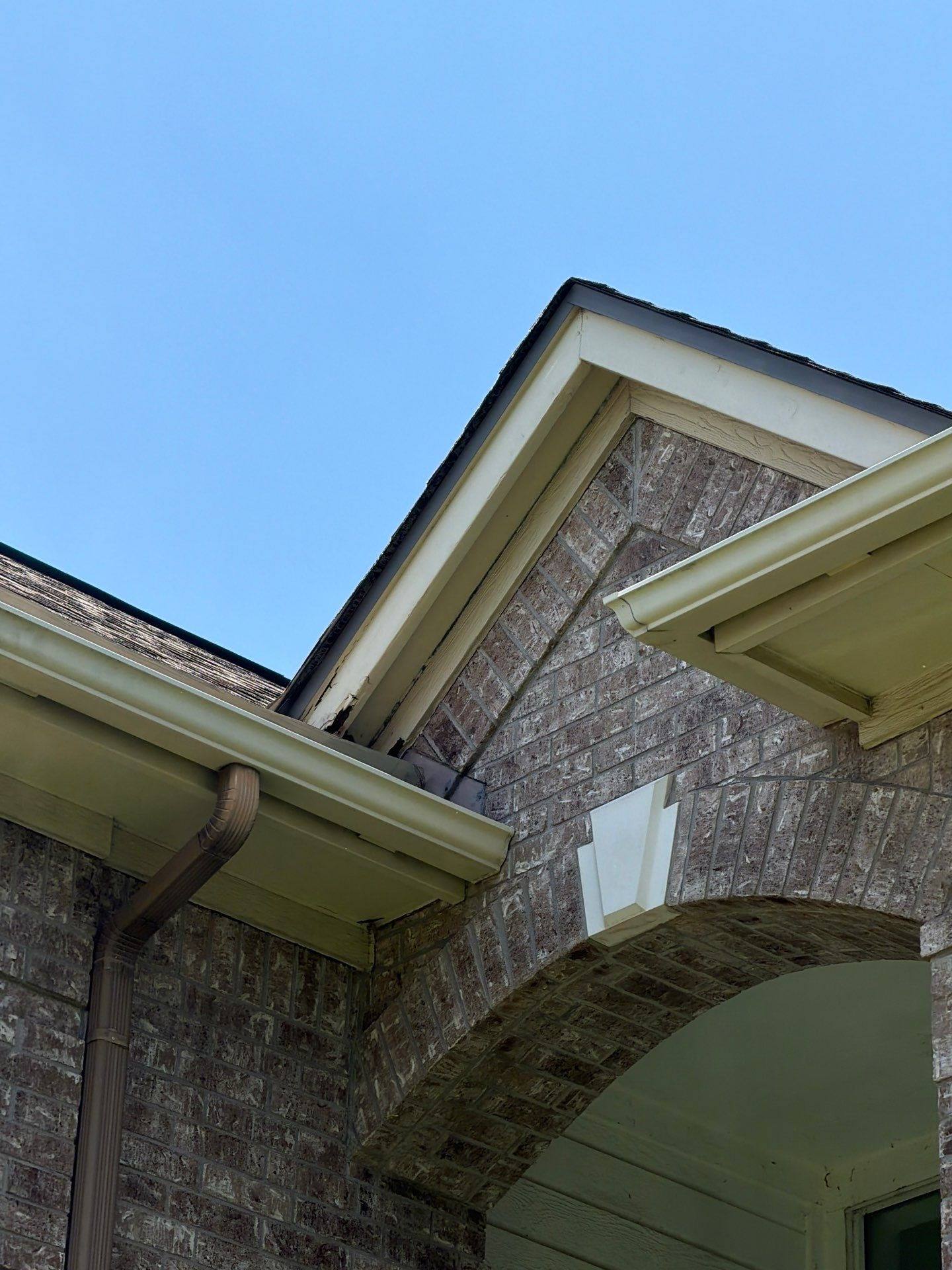 Front porch archway and gutter detail on a home in Austin, TX ahead of exterior painting by Hill Country Painting